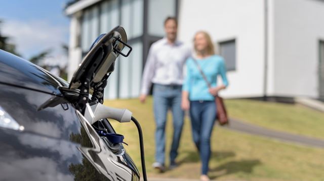 Couple charging electric car